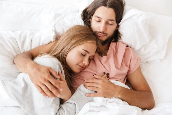 Schönes junges Paar liegt im Bett — Stockfoto