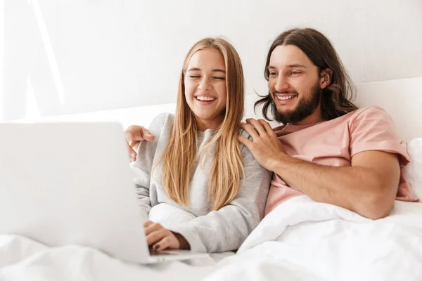 在家里用手提电脑在床上爱夫妻. — 图库照片