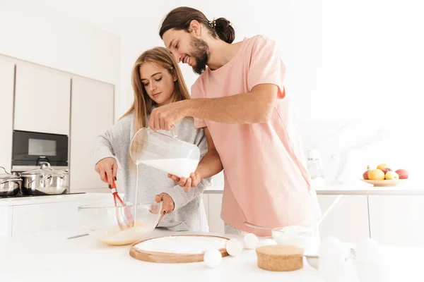 Geconcentreerd jong liefdevol paar in de keuken — Stockfoto