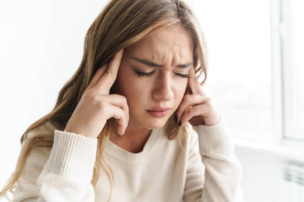 Foto da jovem mulher infeliz com dor de cabeça esfregando seus templos — Fotografia de Stock