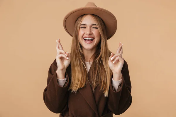 Afbeelding van jong meisje dragen hoed lachen en houden vingers cro — Stockfoto