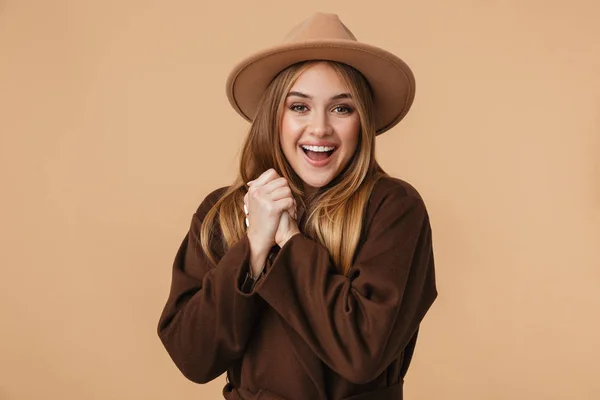 Obrázek mladé kavkazské dívky v klobouku a kabátu s úsměvem v su — Stock fotografie