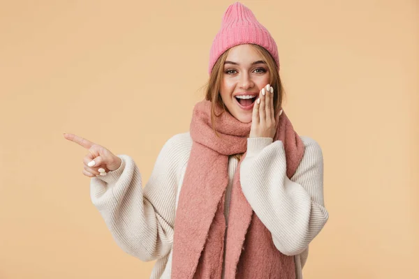 Afbeelding van jong meisje in winterhoed glimlachend en wijzende vinger als — Stockfoto