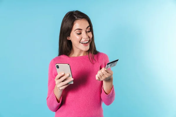 Foto de mulher bonita sorrindo segurando cartão de crédito e celular — Fotografia de Stock