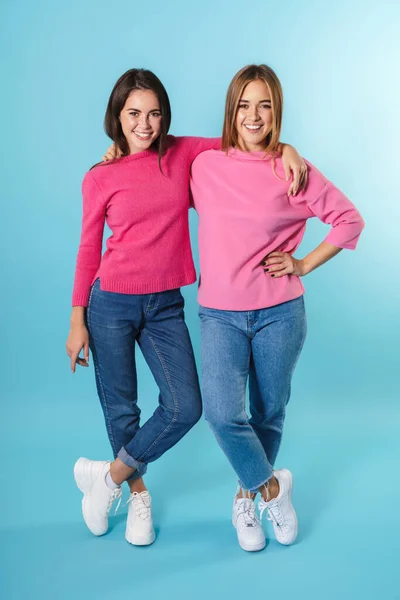 Volledige lengte van twee gelukkige jonge meisjes staan geïsoleerd — Stockfoto