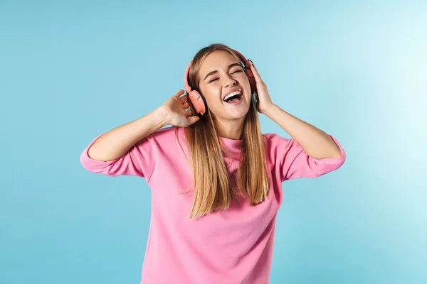 Foto de mujer encantada cantando y escuchando música con auriculares —  Fotos de Stock