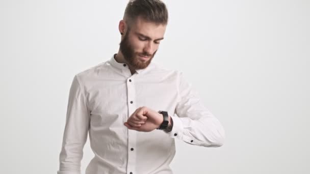 Jovem Barbudo Sério Calmo Está Usando Seu Relógio Inteligente Isolado — Vídeo de Stock