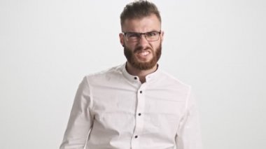 Beyaz gömlek ve gözlük takan genç sakallı bir adam, beyaz duvar arkasında izole edilmiş bir yer olmadığını söylerken negatif işaret ediyor.