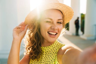 Sokaktan sokağa yürüyen mutlu kadın selfie çek.