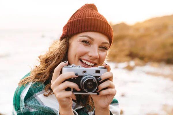Bild av ung kvinna som tar foto på retro kamera när du går — Stockfoto