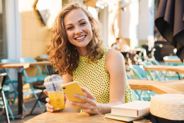 Image de la femme tenant un téléphone portable dans la rue café d'été avec cocktail — Photo