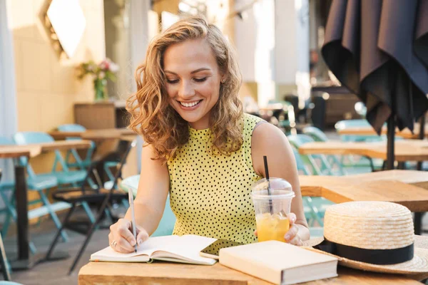 Nő a szabadban kávézó uwriting jegyzetek notebook. — Stock Fotó
