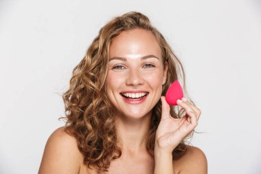 Yarı çıplak, gülen ve elinde sünger tutan bir kadın resmi.