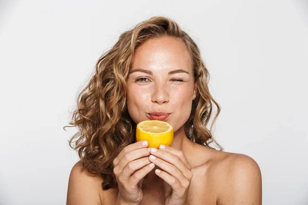 A vonzó félmeztelen nő képe, amint kacsint és citromot eszik — Stock Fotó
