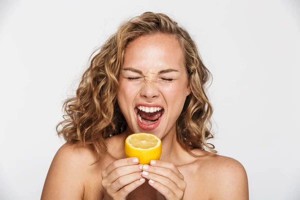 Imagem de mulher semi-nua descontente sorrindo e comendo limão — Fotografia de Stock