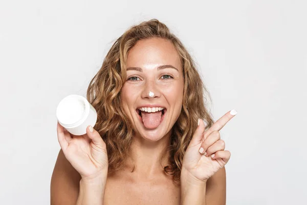 Imagen de mujer alegre semidesnuda burlándose con crema facial — Foto de Stock