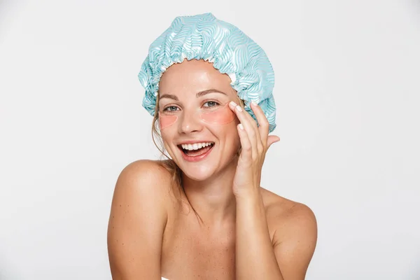 Image of happy woman wearing cosmetic patches and shower cap smiling — Stock Photo, Image