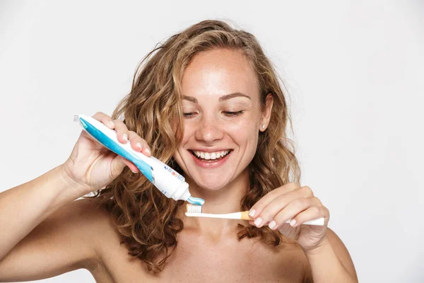 Image of cheerful woman smiling while holding toothpaste and toothbrush — Stock Photo, Image