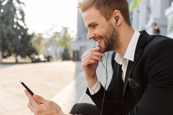 Hadsome młody biznesmen noszący słuchawki stojące — Zdjęcie stockowe