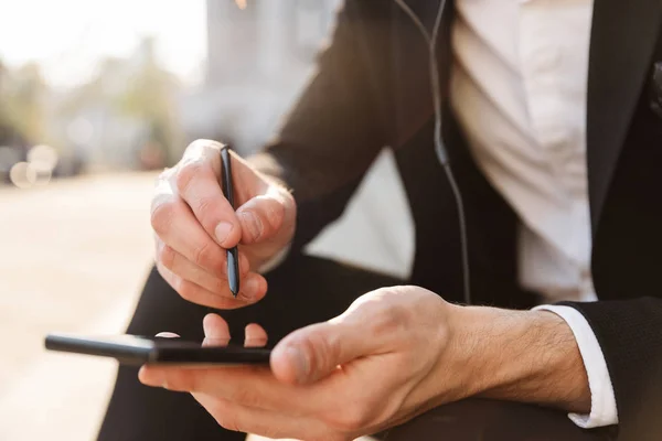 stock image Close up of a businessman using mobile phone and stylus