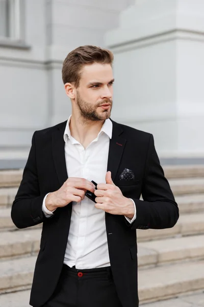 Charming young businessman wearing suit standing at the city — Stock Photo, Image