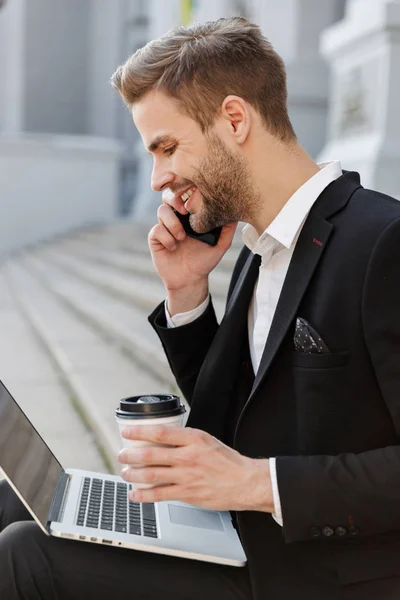 Atraktivní mladý podnikatel v obleku pomocí mobilního telefonu — Stock fotografie