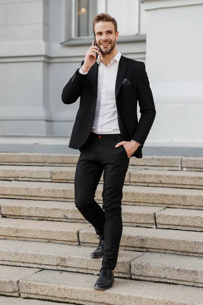Encantador joven hombre de negocios con traje de pie en la ciudad —  Fotos de Stock