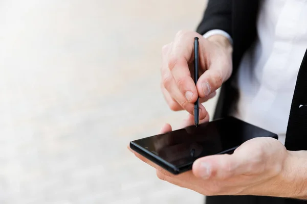 Primer plano de un hombre de negocios usando teléfono móvil y lápiz — Foto de Stock