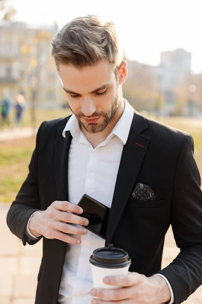 Jovem empresário encantador vestindo terno em pé na cidade — Fotografia de Stock