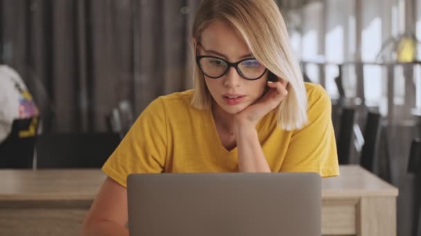 Uma Jovem Calma Pensativa Usando Óculos Está Trabalhando Seu Laptop — Vídeo de Stock