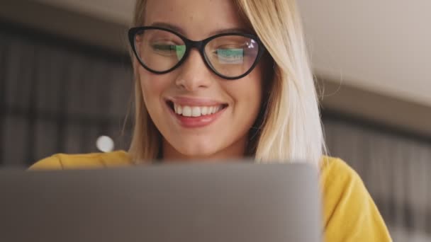 Detailní Pohled Usmívající Blondýnu Brýlemi Pracuje Svém Notebooku Zatímco Sedí — Stock video