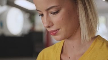 A close-up view of beautiful focused calm woman is using a smartphone in a conference hall
