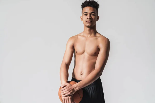 Retrato de un afroamericano sin camisa haciendo ejercicio con baloncesto — Foto de Stock