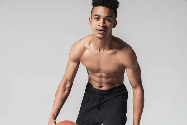 Retrato de un afroamericano sin camisa haciendo ejercicio con baloncesto — Foto de Stock