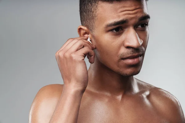 Photo closeup of shirtless african american man using earpod — Stock Photo, Image