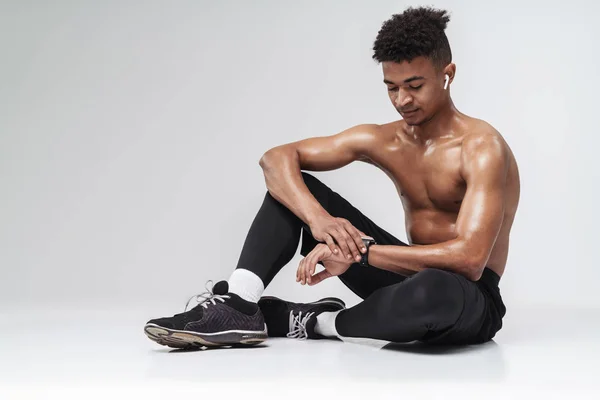 Photo of shirtless african american man using earpods and smartwatch — Stock Photo, Image