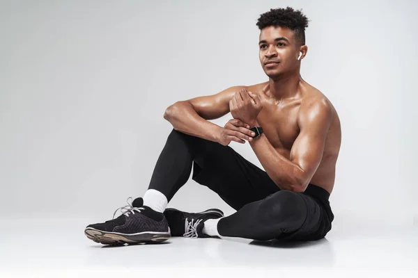 Photo of shirtless african american man using earpods and smartwatch — Stock Photo, Image