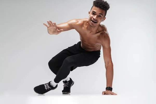 Foto de hombre afroamericano usando auriculares y haciendo ejercicio — Foto de Stock