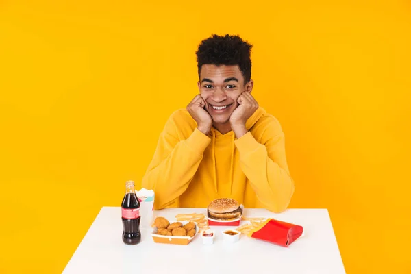 Boldog afrikai tinédzser fiú gyorskaját eszik — Stock Fotó