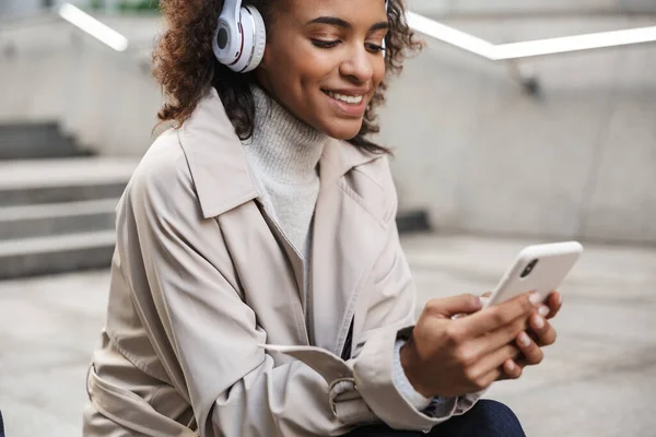 Smiling young african woman wearing autumn coat — Stock Photo, Image