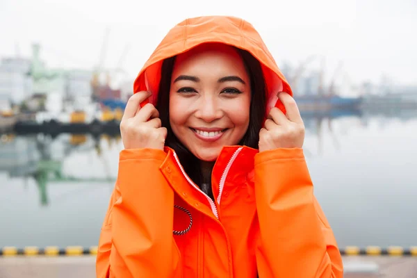 Sonriente atractivo joven asiático mujer usando impermeable —  Fotos de Stock