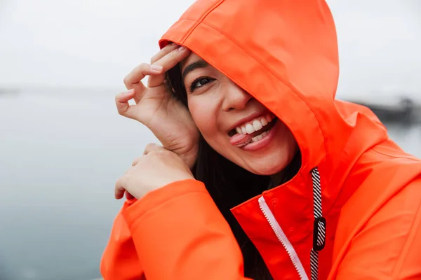 Sonriente atractivo joven asiático mujer usando impermeable —  Fotos de Stock