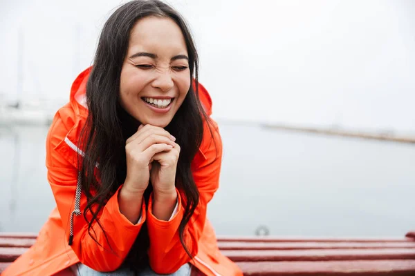 Sorrindo atraente jovem asiático mulher vestindo capa de chuva — Fotografia de Stock