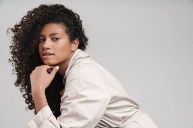 Attractive young african woman wearing autumn coat stting