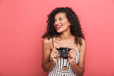 Image of cheerful african american woman photographing on retro 