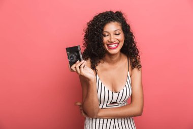 Image of brunette african american woman photographing on retro 