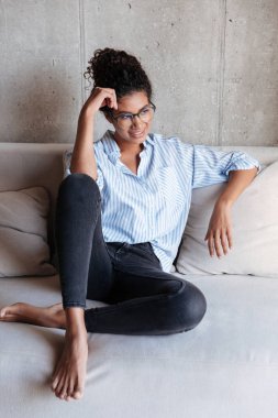 Smiling attractive young african woman wearing shirt relaxing