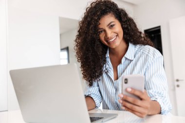 Attractive young african woman working on laptop computer