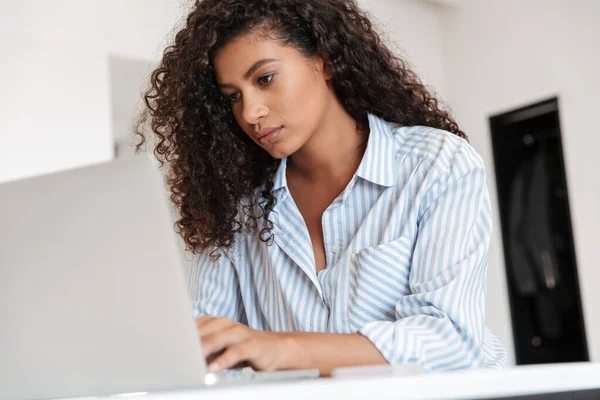 Jovem mulher africana atraente trabalhando no computador portátil — Fotografia de Stock