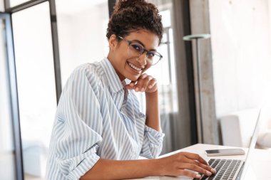 Attractive young african woman working on laptop computer
